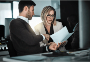Screenshot-2023-04-06-124509 - Aryo Systems Two business professionals reviewing a document together in a modern office setting.